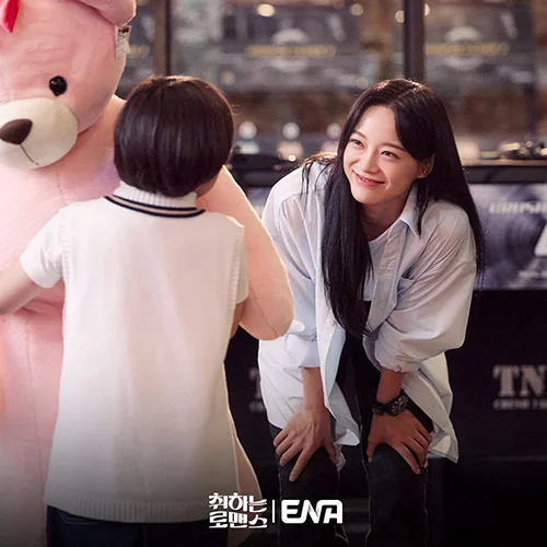 Kim Se-jeong smiling looking at a child holding a doll