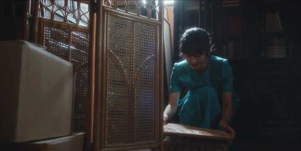 Han Jung-sook looking at a box in Geum-hee's storage room.